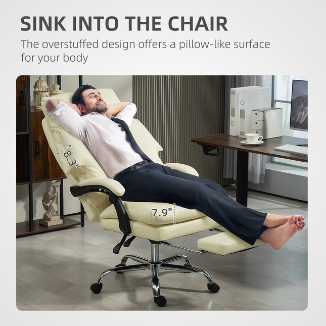 A man relaxes in a cream white overstuffed office chair with a footrest.