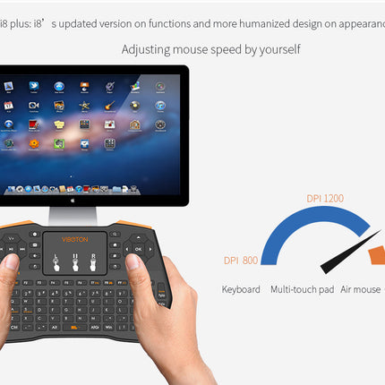 A person holds a black wireless mini keyboard with orange accents, featuring a touchpad and various buttons.