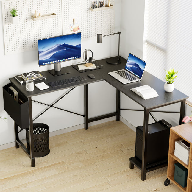 An L-shaped computer desk with a black top and metal frame, shown in a home office.