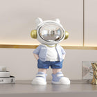 Astronaut table metal decoration in loungewear, with a reflective helmet and gold headphones.