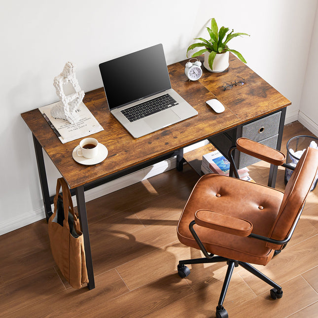 A rustic computer desk with a laptop, coffee, plant, and chair.
