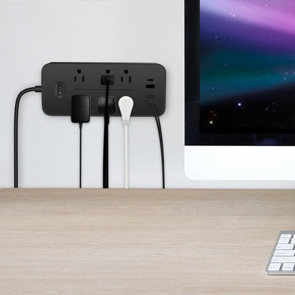 A black USB power strip with six outlets and three USB ports is plugged into a wall.